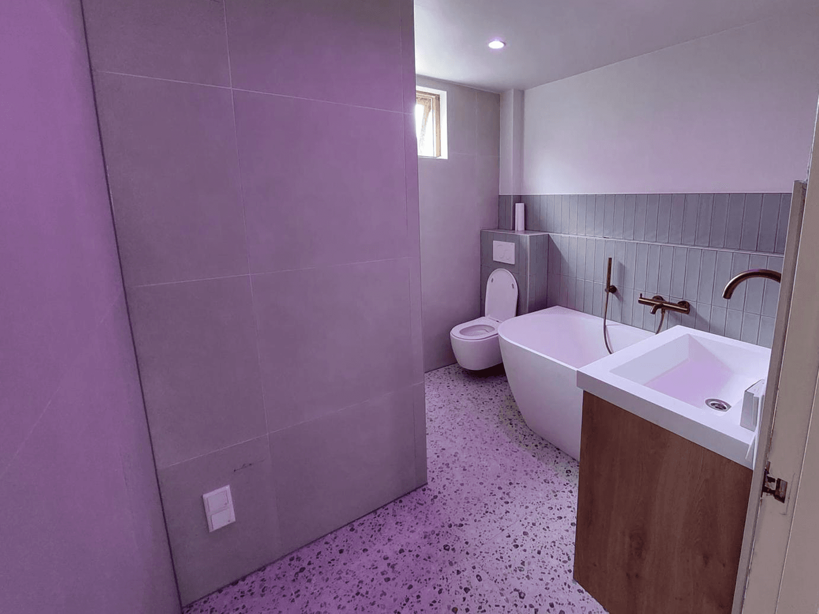 Badkamer met wastafelmeubel, bad en afgewerkte vloer